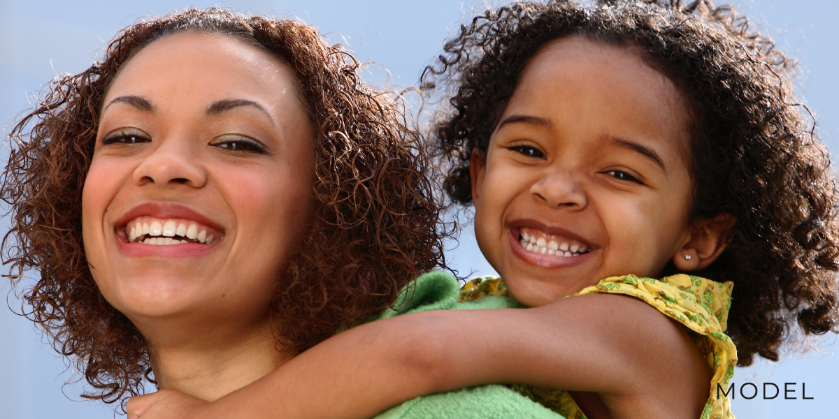 Model of Mom and Daughter Smiling Outdoors