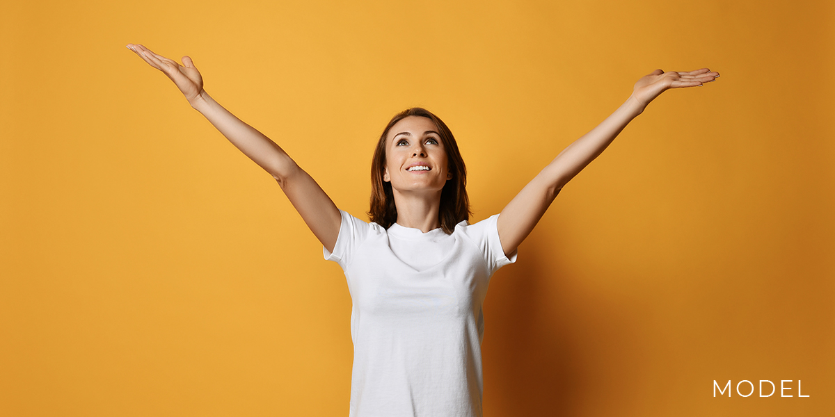 Model with Her Arms Outstretched Against an Orange Background