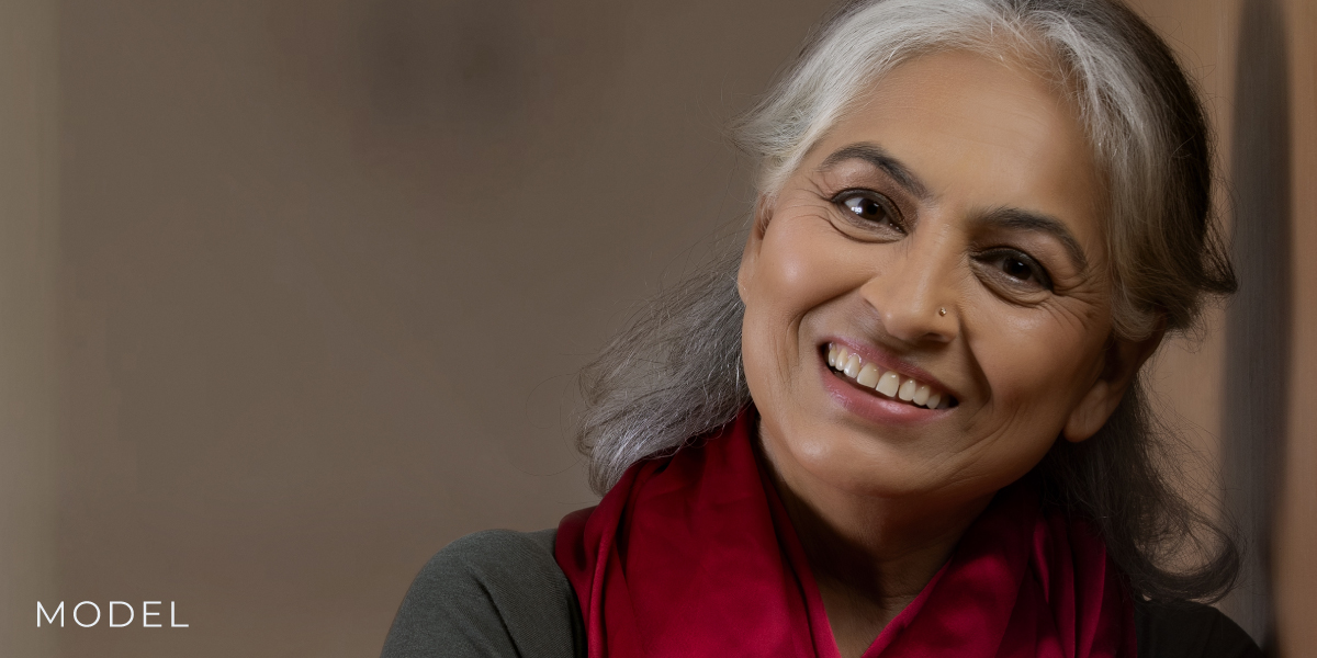 Older Woman Leaning Against Dark Background