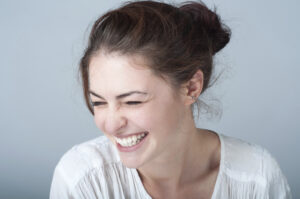 Smiling model in a white shirt | perri dermatology