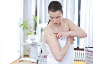 Woman touches spot on shoulder