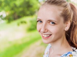 Young female with freckles standing outdoors