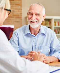 Older model couple enjoying a conversation at the dinner table | perri dermatology